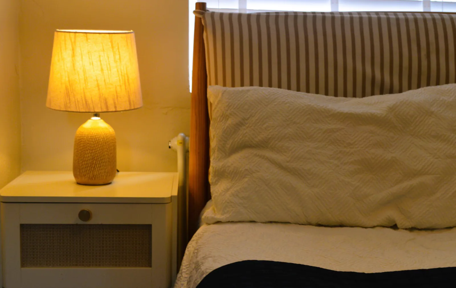 Airbnb bedroom with bedside lamp and bed